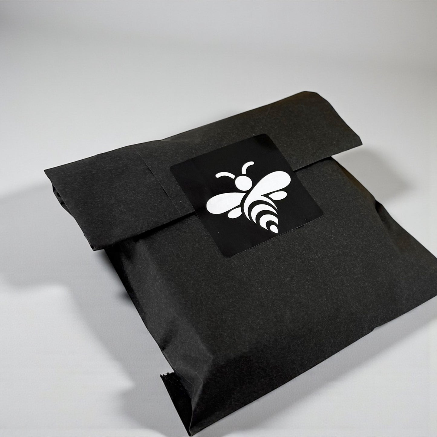Black envelope with a white bee logo on a light gray background