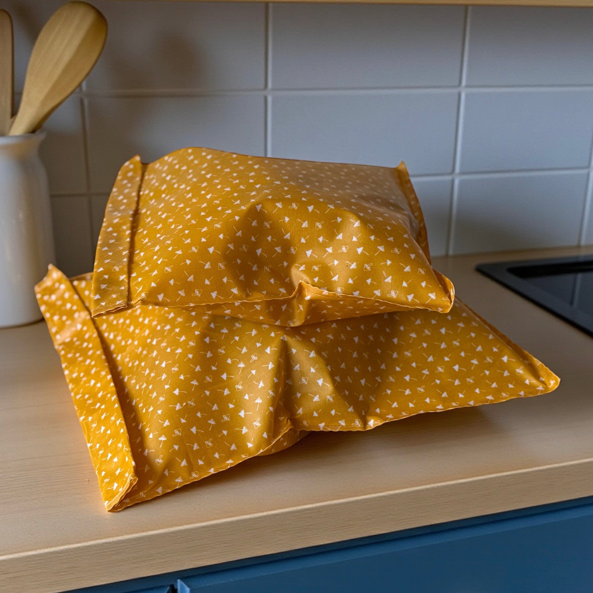 Yellow patterned bags on a kitchen counter with tiled wall in the background