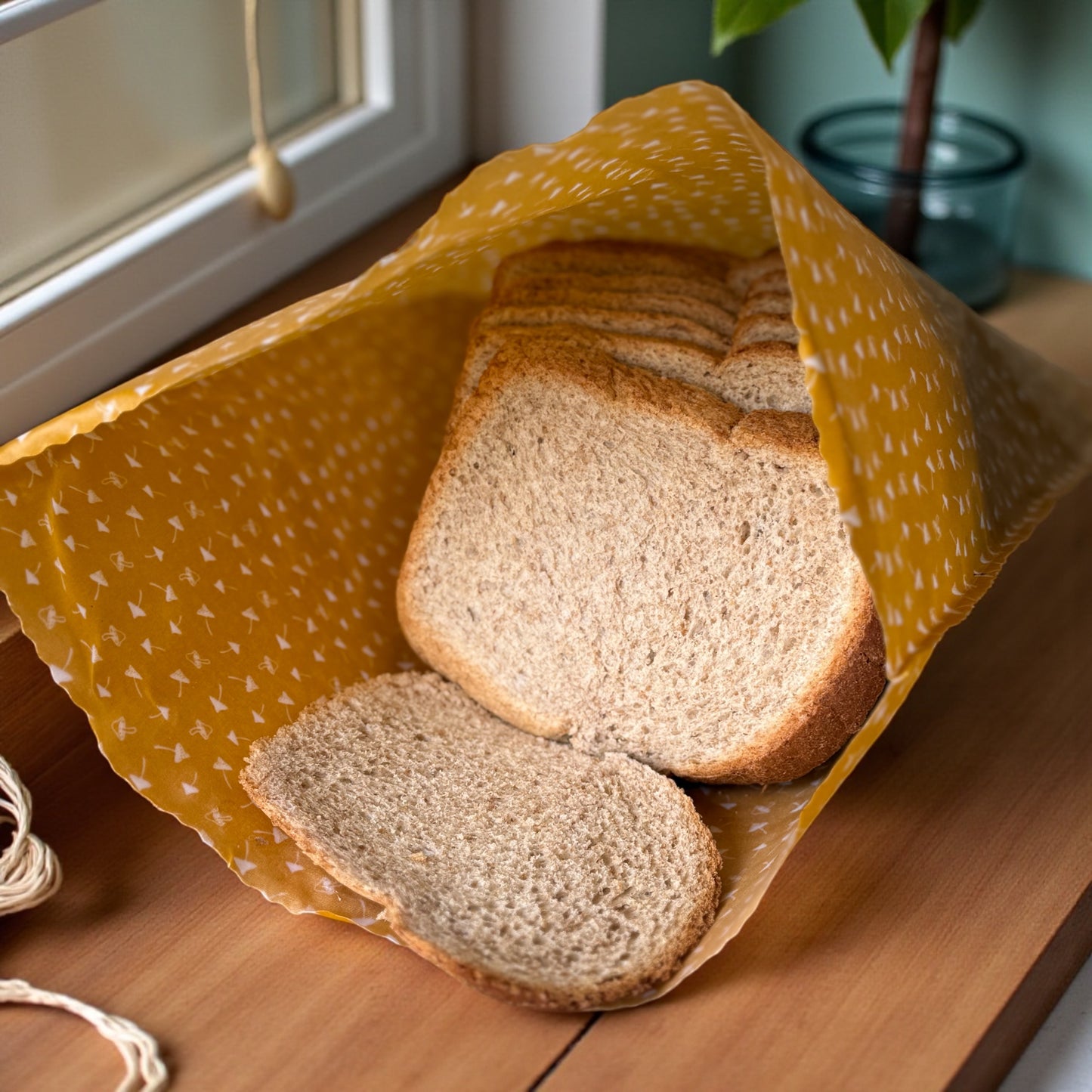 Loaf of bread sliced on a wooden surface with yellow cloth
