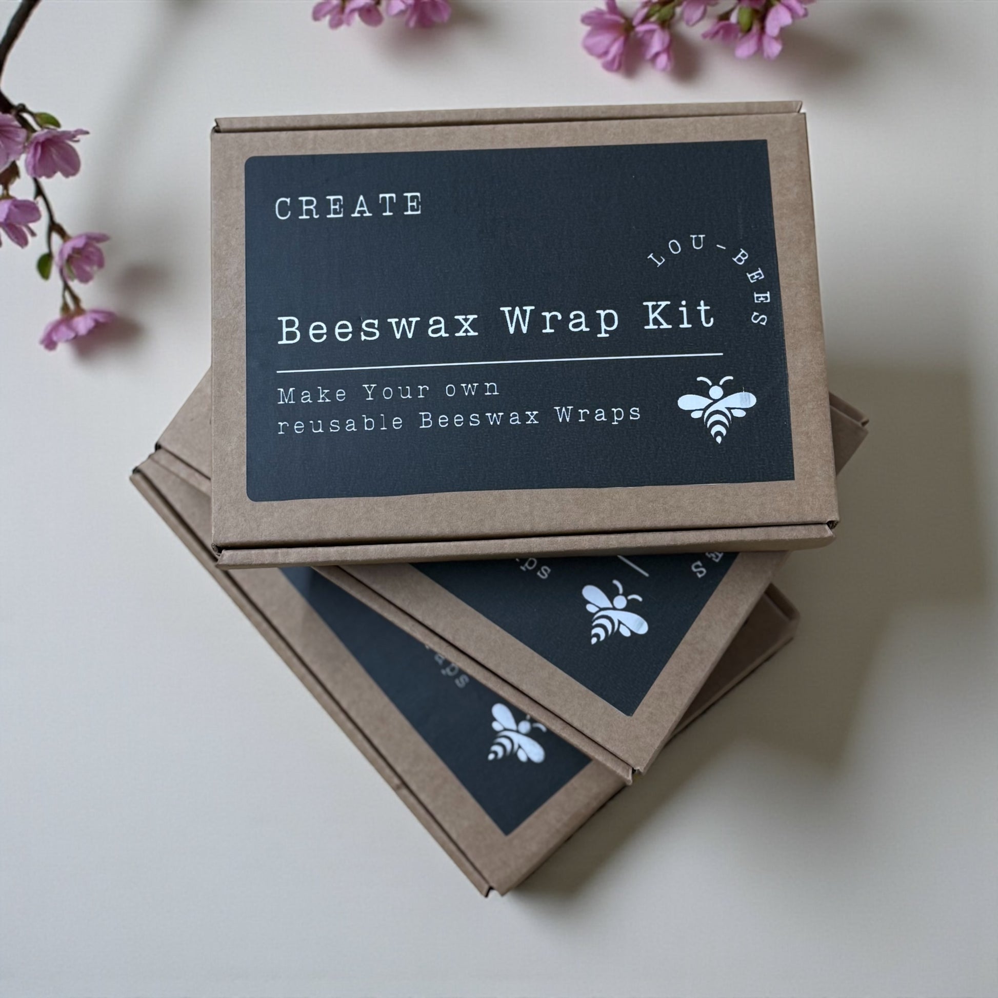 Beeswax wrap kit packaging with cherry blossoms on a light background